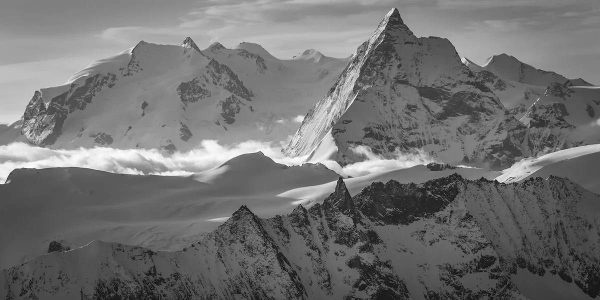 Black-and-white photograph of snow-covered Swiss mountains